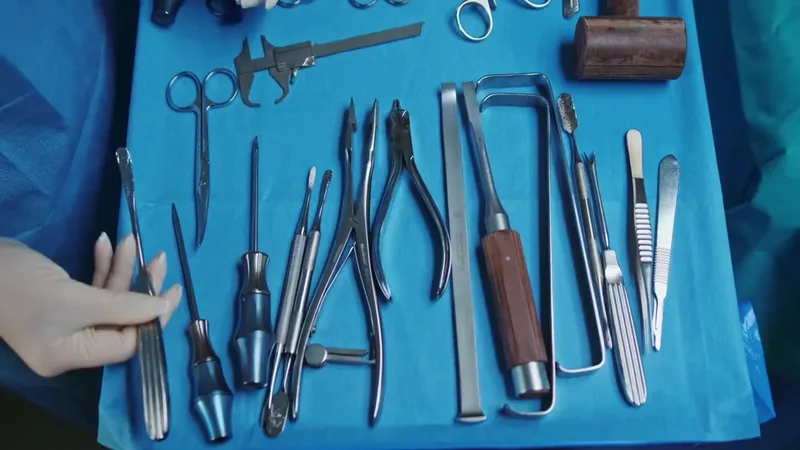 Manos con guantes preparando instrumental sobre una mesa azul. Escena genérica.